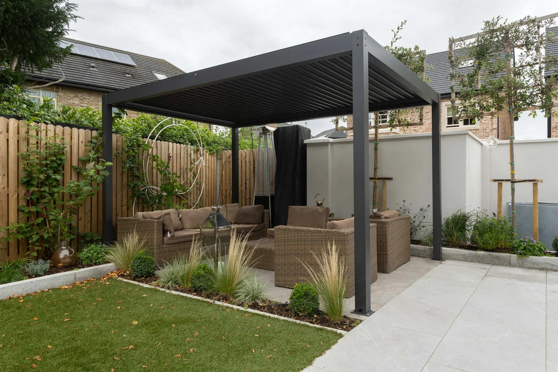 Modern dark louvered pergola in landscaped small yard